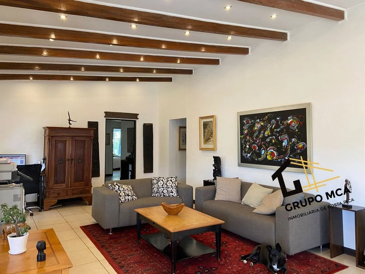 Sala con vigas de madera y cuadro grande