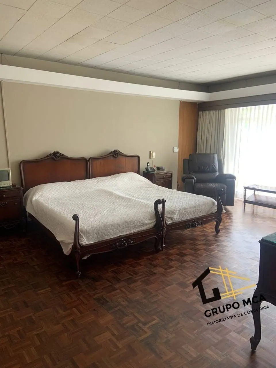 Dormitorio con piso de parqué