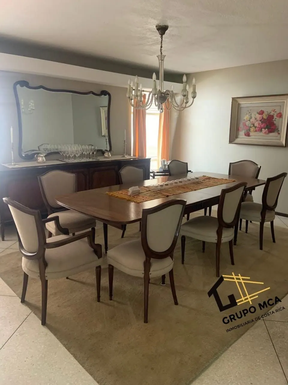 Comedor formal con espejo y lámpara de cristal