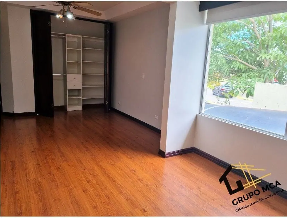 Dormitorio con piso de madera y ventana