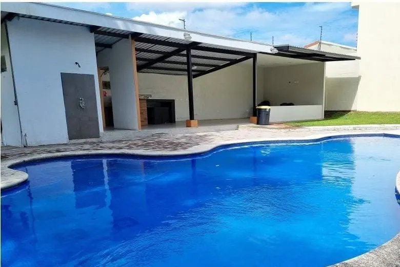 Piscina del condominio rodeada de zacate