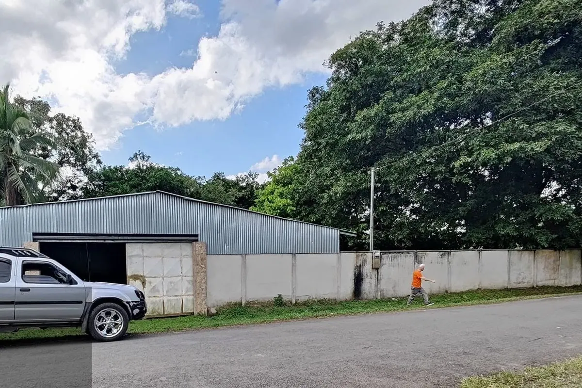 Galerón de estructura metálica con un carro al frente